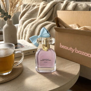 Marc Jacobs Perfect Elixir 30 ml auf Wohnzimmer-Coffee-Table mit beauty bazaar Versandkarton im goldenen Tageslicht